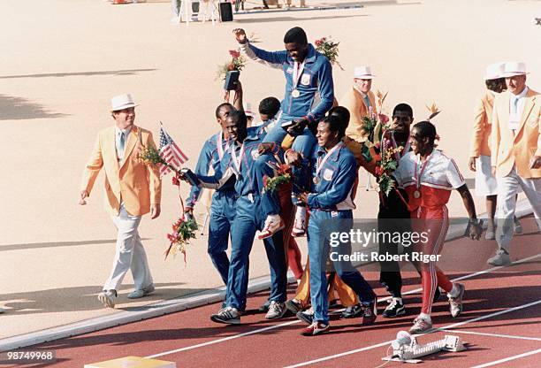 Carl Lewis of the United States is carried on the shoulders of his teammates Calvin Smith, Sam Graddy and Ron Brown following the Gold Medal win in...