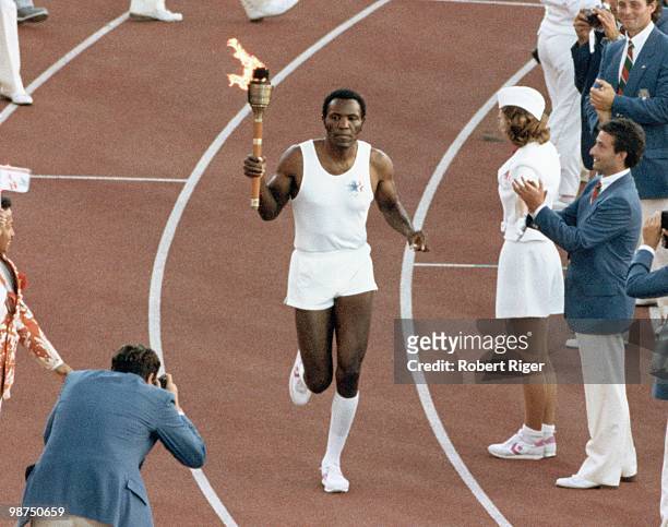 Rafer Johnson carries the Olympic Torch during the Opening Ceremony of the 1984 Summer Olympics at the Los Angeles Memorial Coliseum on July 28, 1984...