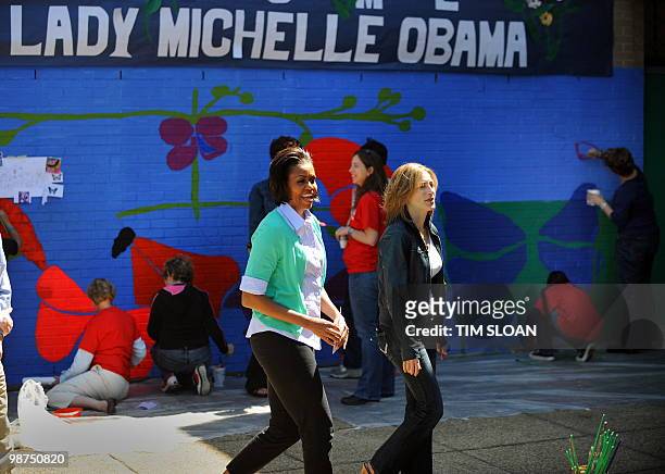 First Lady Michelle Obama and Congressional spouses help to paint a mural and plant a butterfly garden on April 28, 2010 at the Marie Reed Community...