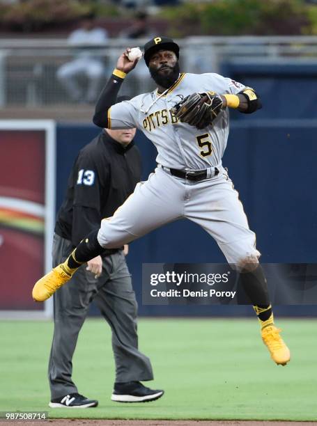 Josh Harrison of the Pittsburgh Pirates jumps as he throws out Eric Hosmer of the San Diego Padres during the first inning of a baseball game at...