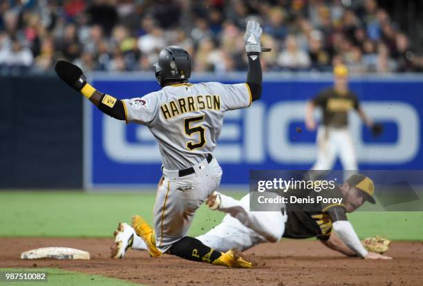 Josh Harrison of the Pittsburgh Pirates slides safely into second base as Cory Spangenberg of the San Diego Padres is pulled off the base by a bad...