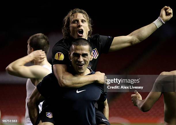 Diego Forlan of Atletico Madrid celebrates with his team mate Juanito at the end of the UEFA Europa League Semi-Final Second Leg match between...