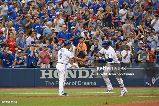 Toronto Blue Jays First base Justin Smoak celebrates a two run homer with third base coach Luis Rivera during the regular season MLB game between the...
