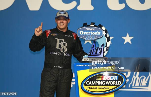 Brett Moffitt, driver of the Fr8Auctions.com Toyota, poses with the trophy after winning the NASCAR Camping World Truck Series Overton's 225 at...