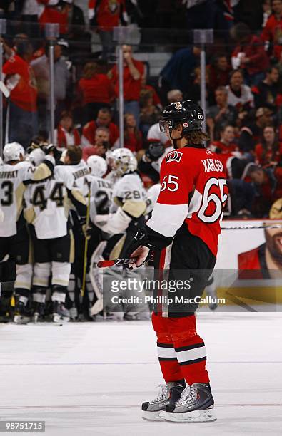 Dejected Erik Karlsson of the Ottawa Senators stands on the ice as the Pittsburgh Penguins celebrate in Game 6 of the Eastern Conference Quaterfinals...