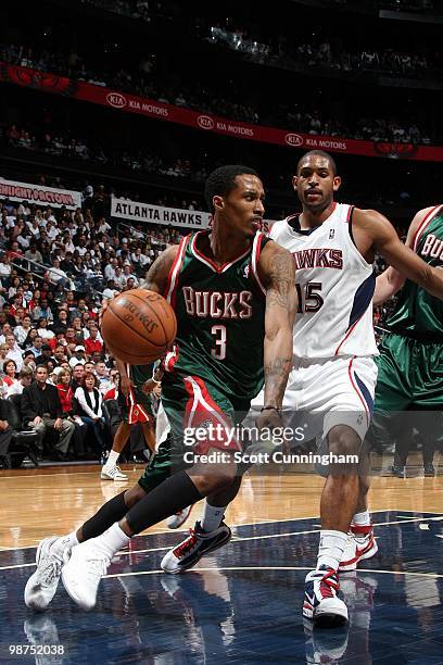 Brandon Jennings of the Milwaukee Bucks looks to make a play as he drives to the basket against Al Horford of the Atlanta Hawks in Game Five of the...