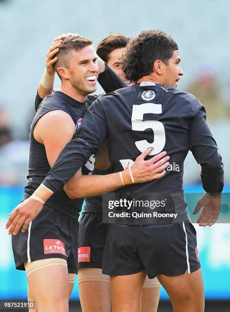 Marc Murphy of the Blues is congratulated by team mates after kicking a goal during the round 15 AFL match between the Carlton Blues and the Port...