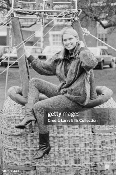 Welsh television presenter Anneka Rice, who hosts the television game show 'Treasure Hunt', pictured seated on a hot air balloon wicker basket circa...