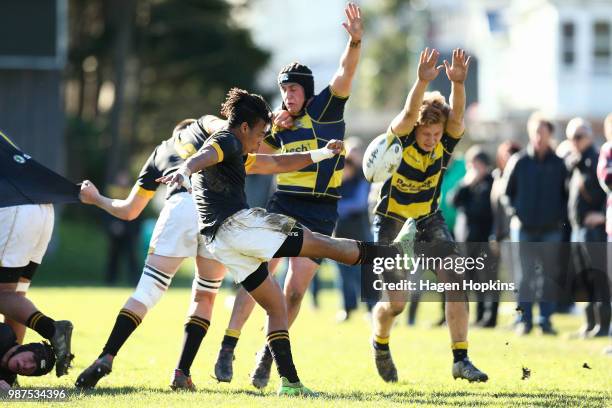 Adam Gordon and Tama Bartlett of Wairarapa College attempt to block the kick of Ishmael Perkins-Banse of Wellington College during the schoolboys...