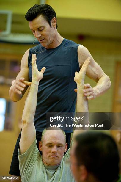 Fitness instructor Tony Horton assists Everett Powers with a stretching. Horton is in DC to teach a few classes on military bases, capitol hill and...