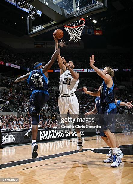 Tim Duncan of the San Antonio Spurs shoots against Brendan Haywood and Dirk Nowitzki of the Dallas Mavericks in Game Six of the Western Conference...