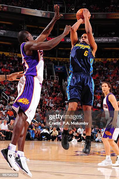 Arron Afflalo of the Denver Nuggets shoots over Jason Richardson of the Phoenix Suns during the game at U.S. Airways Center on April 13, 2010 in...