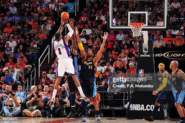 Amar'e Stoudemire of the Phoenix Suns shoots over Johan Petro and Nene of the Denver Nuggets during the game at U.S. Airways Center on April 13, 2010...