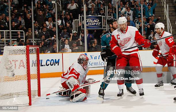 Jimmy Howard, Nicklas Lidstrom and Brad Stuart of the Detroit Red Wings and Ryane Clowe of the San Jose Sharks react to a goal in Game One of the...