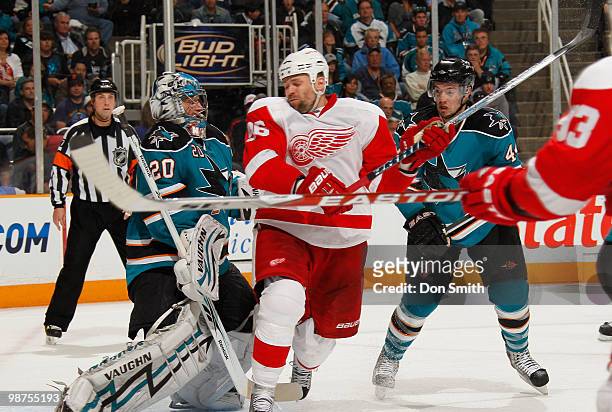Tomas Holmstrom of the Detroit Red Wings stands in front of the net against Evgeni Nabokov and Marc-Edouard Vlasic of the San Jose Sharks in Game One...