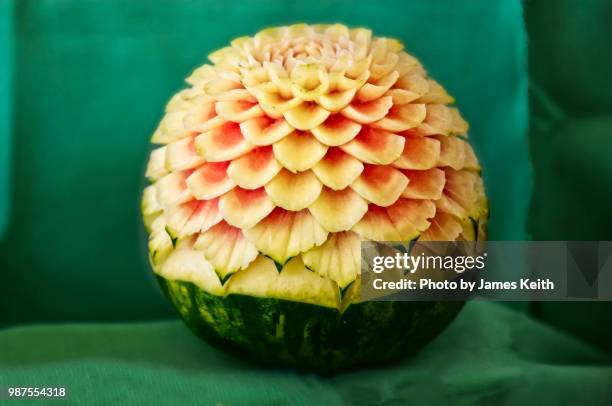 fruit carving is a form of arts and crafts quite common in the orient.  the sample shown here is a flower carved from a watermelon. - thai fruit carving stock pictures, royalty-free photos & images