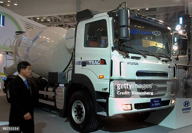 Visitor passes in front of a Hyundai Motor Co. Truck display at the Busan International Motor Show 2010 in Busan, South Korea, on Thursday, April 29,...
