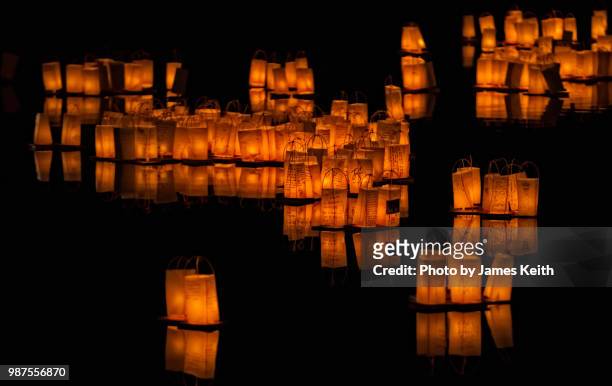 toro nagashi is a long-held japanese tradition where candle-lit lanterns are released into rivers to guide the spirits of ancestors back to the other world during the obon season. - lantern water stock-fotos und bilder