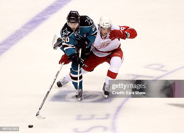 Jason Demers of the San Jose Sharks and Justin Abdelkader of the Detroit Red Wings go for the puck in Game One of the Western Conference Semifinals...
