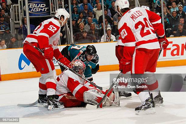 Jimmy Howard, Drew Miller and Jonathan Ericsson of the Detroit Red Wings keep the puck out against Logan Couture of the San Jose Sharks in Game One...