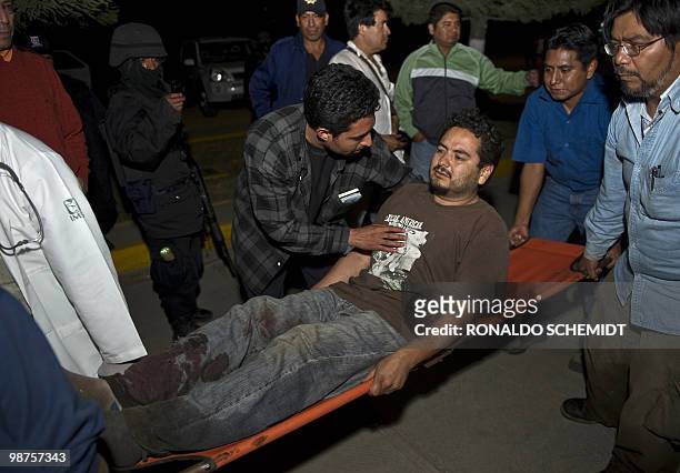 Mexican photographer David Cilia is helped by friends to hospital in Santiago Juxtlahuaca on April 30, 2010. Cilia managed escaped by hidding in the...