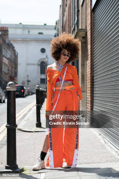 Fashion blogger Sarah Guessab wears a Tommy Hilfiger bra, Champion trousers, Urban Outfitters sunglasses, House of London jacket and Yeezy trainers...