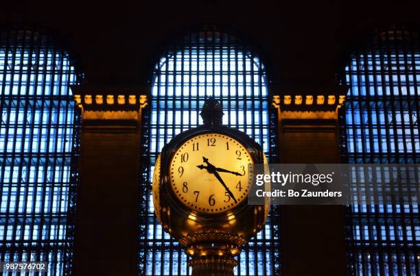 the clock on top the information booth in the concourse of grand central terminal, in nyc. - grand central station manhattan stock pictures, royalty-free photos & images