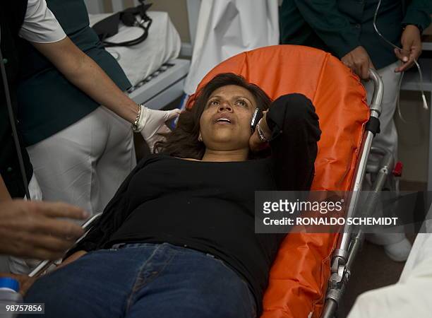 Mexican journalist Erika Ramirez talks on her phone as she is helped by doctors in a hospital of Santiago Juxtlahuaca on April 30, 2010. Ramirez...