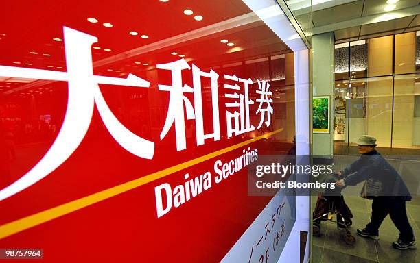 Pedestrians walk past a Daiwa Securities Group Inc. Branch in Tokyo, Japan, on Friday, April 30, 2010. Daiwa Securities Group Inc., Japan's...