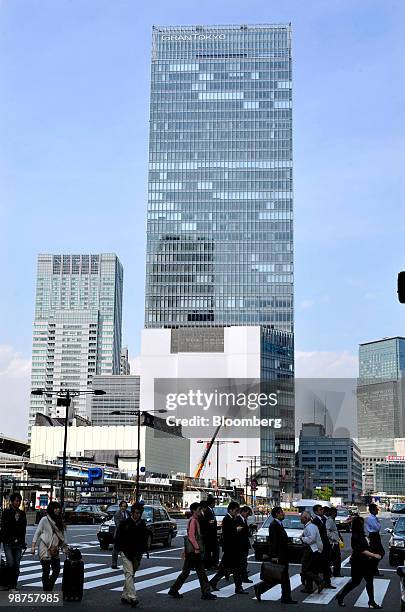 Pedestrians walk past the building where the headquarters of Daiwa Securities Group Inc. Are located in Tokyo, Japan, on Friday, April 30, 2010....