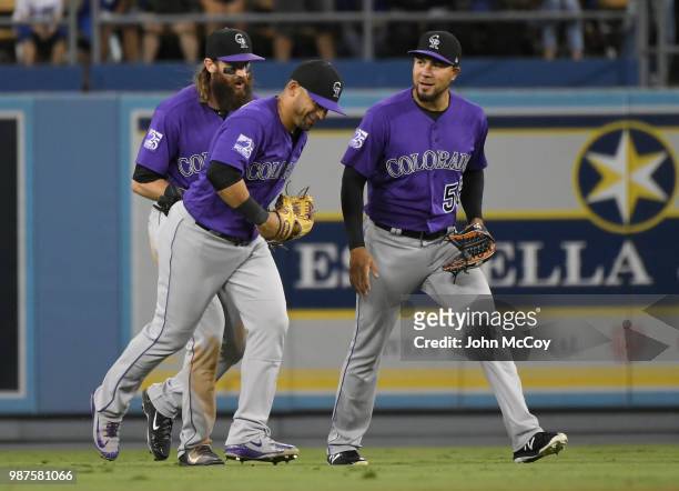 Charlie Blackmon, Gerardo Parra and Noel Cuevas of the Colorado Rockies celebrate a 3-1 win over the Los Angeles Dodgers at Dodger Stadium on June...