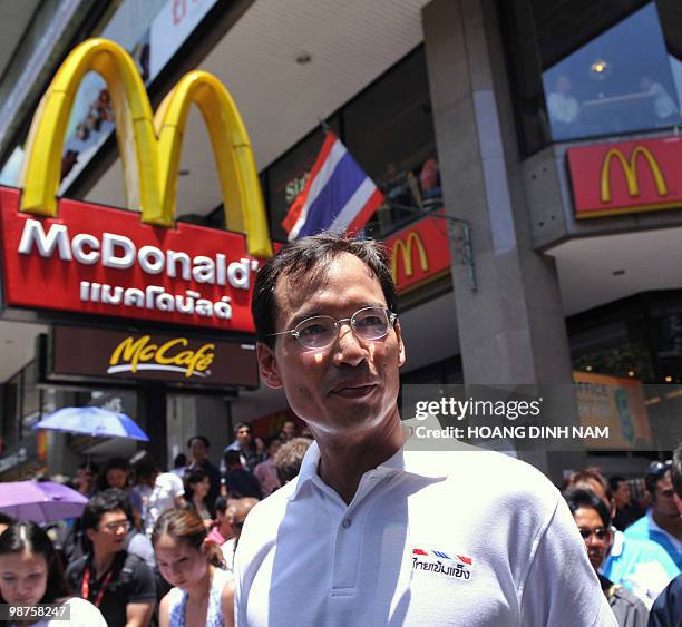 Thailand's Finance Minister Korn Chatikavanij walks on Silom road as he pays a visit to security forces guarding Silom road, near to a "Red-Shirt"...