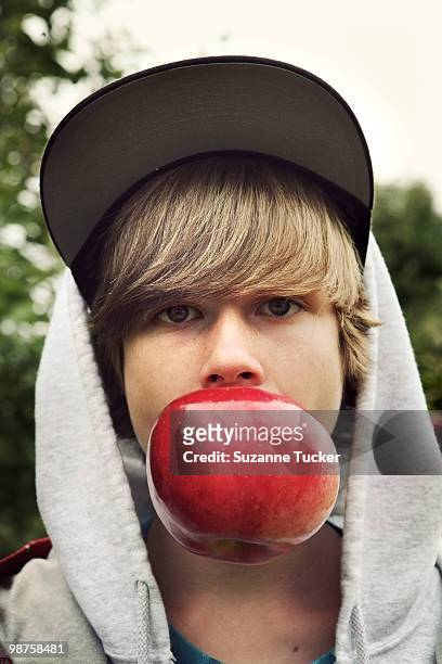 boy biting a very big apple - im mund tragen stock-fotos und bilder