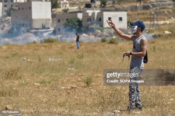 Palestinian protesters use slings to hurl rocks and bottles at Israeli forces during clashes near Beit El on the outskirts of the West Bank city of...