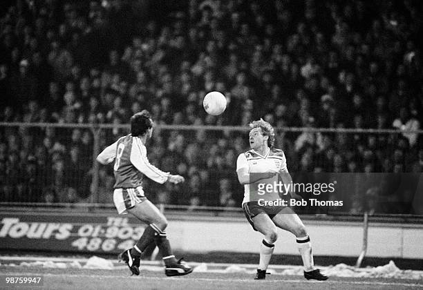 England defender Derek Statham keeps his eyes on the ball as Brian Flynn of Wales moves in during the British Championship match held at Wembley...