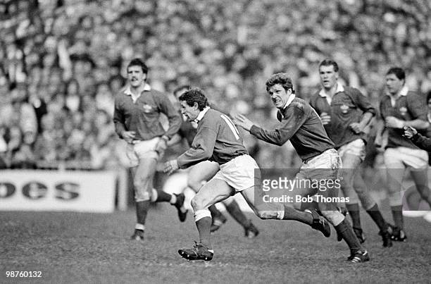 Wales wing Elgan Rees is chased by Fergus Slattery of Ireland during the Rugby Union International match held at Cardiff Arms Park on 5th March 1983....