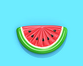 Inflatable watermelon slice on blue background
