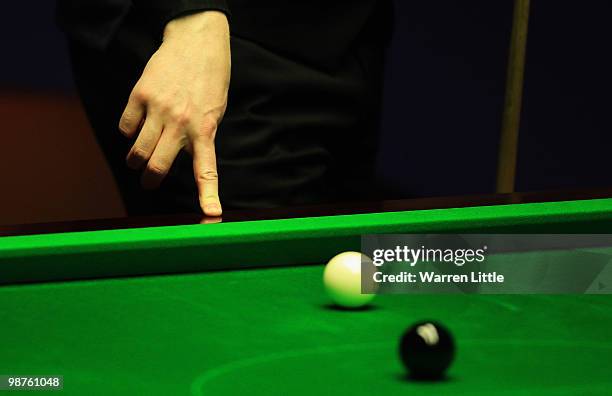 Neil Robertson of Australia rests his finger on the table as he ponders a shot against Ali Carter of England during the semi final of the Betfred.com...
