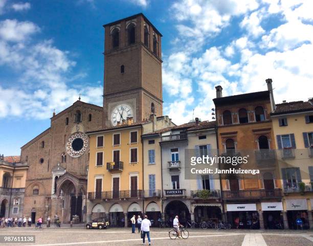 lodi, italy: piazza duomo with pedestrians and bicyclist - lodi lombardy stock pictures, royalty-free photos & images