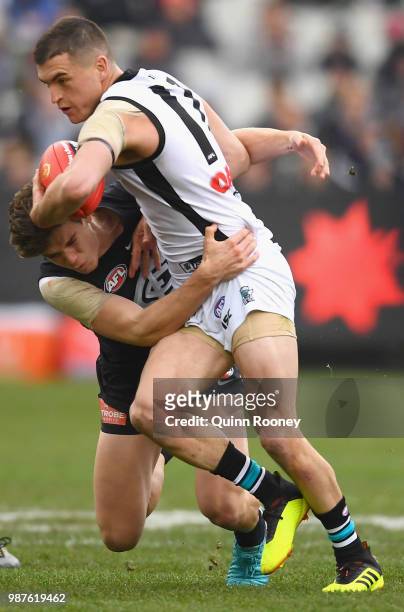 Tom Rockliff of the Power is tackled by Paddy Dow of the Blues during the round 15 AFL match between the Carlton Blues and the Port Adelaide Power at...