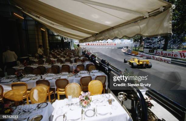 Ayrton Senna drives the Camel Team Lotus Honda Lotus 99Tpast waiters and tables of a restuarant overlooking the circuit during practice for the Grand...