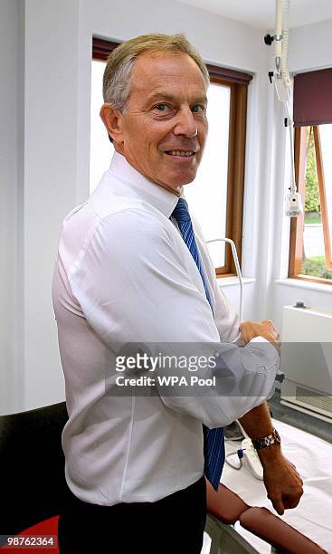 Former Prime Minister Tony Blair rolls up his sleeve to have his blood pressure taken by Nurse Paula Martin during a visit to Alexandra Avenue Health...