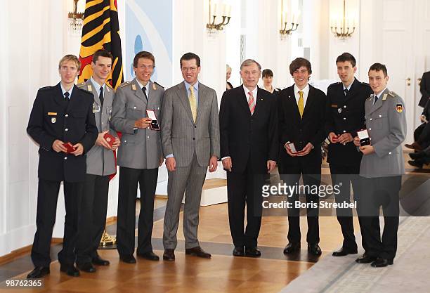 German President Horst Koehler and German Defense Minister Karl-Theodor zu Guttenberg pose with Michael Uhrmann and Andreas Wank of the German flying...