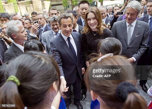 French President Nicolas Sarkozy , his wife Carla Bruni-Sarkozy and French actor Alain Delon are greeted by girls as they walk in the French...