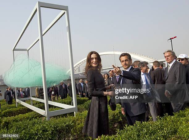 French President Nicolas Sarkozy , his wife Carla Bruni-Sarkozy and French actor Alain Delon walk in the French pavilion, during a visit at the...