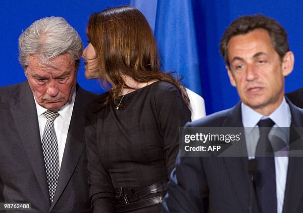 French First Lady Carla Bruni-Sarkozy speaks with French actor Alain Delon as they attend a speech by President of France Nicolas Sarkozy delivered...