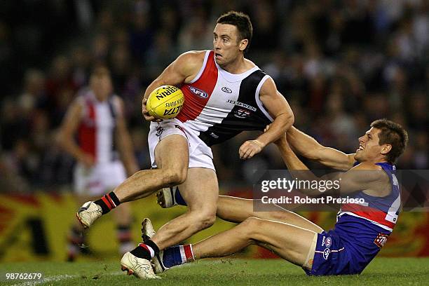 Stephen Milne of the Saints is tackled by Ryan Hargrave of the Bulldogs during the round six AFL match between the Western Bulldogs and the St Kilda...