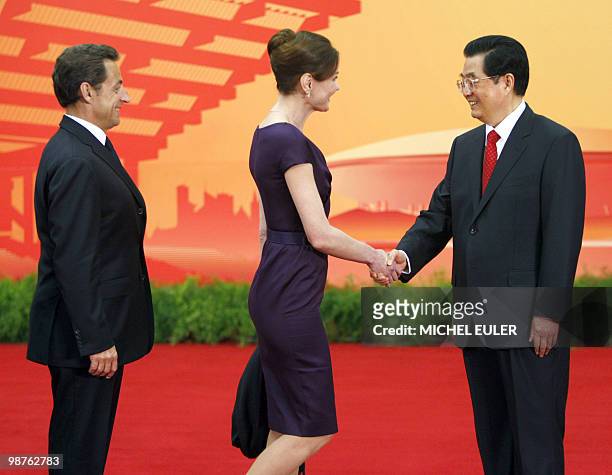 Fench President Nicolas Sarkozy looks at his wife Carla Bruni-Sarkozy as she shakes hand with Chinese President Hu Jintao, during a welcome ceremony...