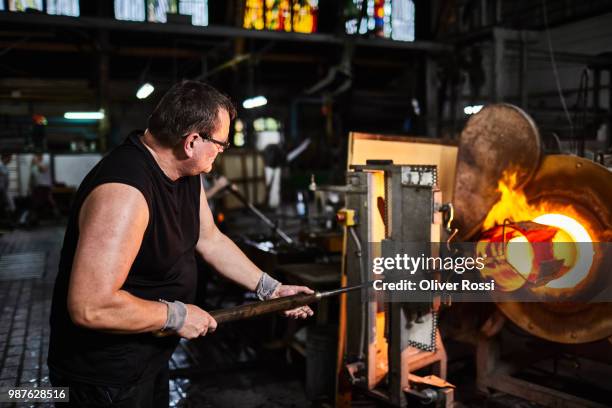 man working at furnace in a glass factory - blowgun stock pictures, royalty-free photos & images