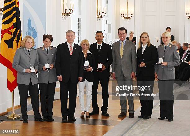 German President Horst Koehler and German Defense Minister Karl-Theodor zu Guttenberg pose with the German figur skaters Aljona Savchenko and Robin...